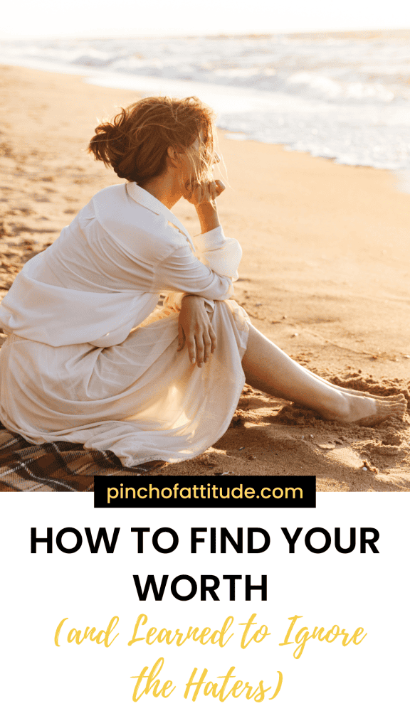 Pinterest - Pin with title "How to Find Your Worth (and Learned to Ignore the Haters)" showing a woman sitting on the beach with waves in the background, wearing a white outfit and gazing into the distance.