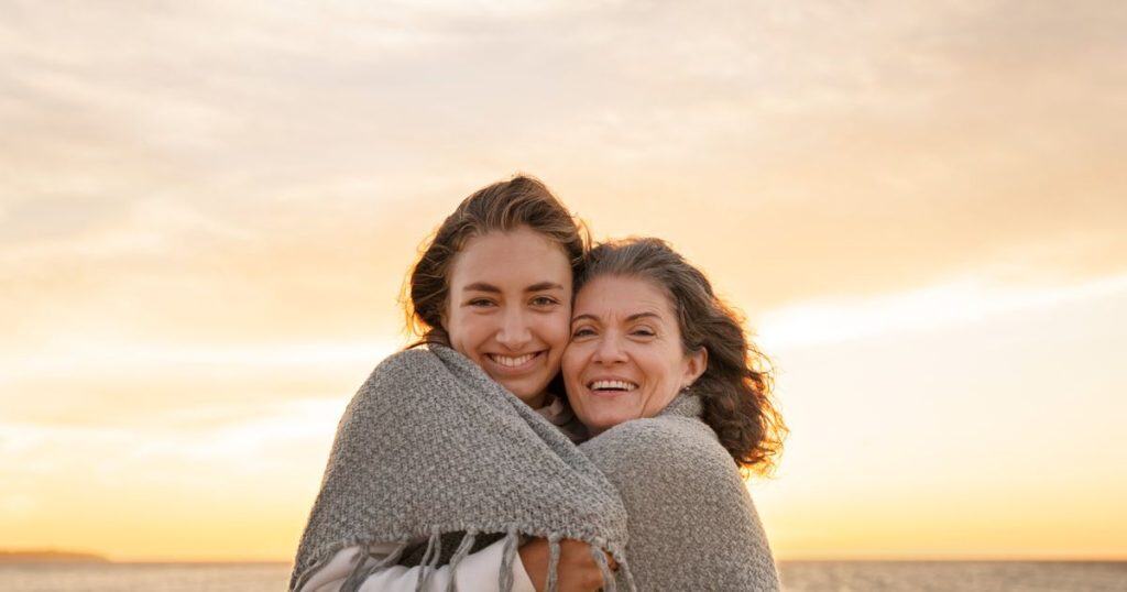 a mother and daughter hugging each other with big comforting towel around them smiling. They are happy as they are done with narcissists in their lives.