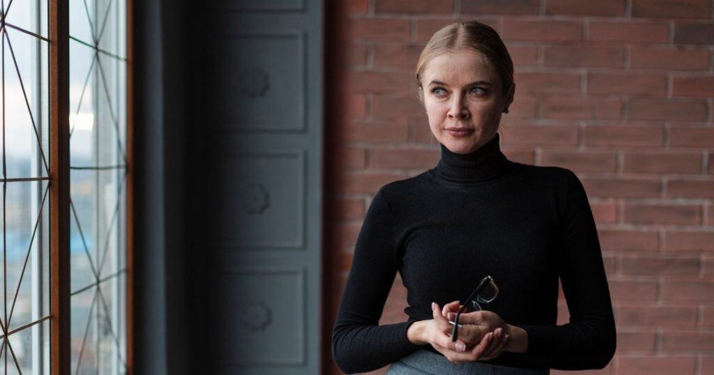 a woman standing confident and elegant looking fierce with her stare as she's no longer giving narcissists a drop of her attention.