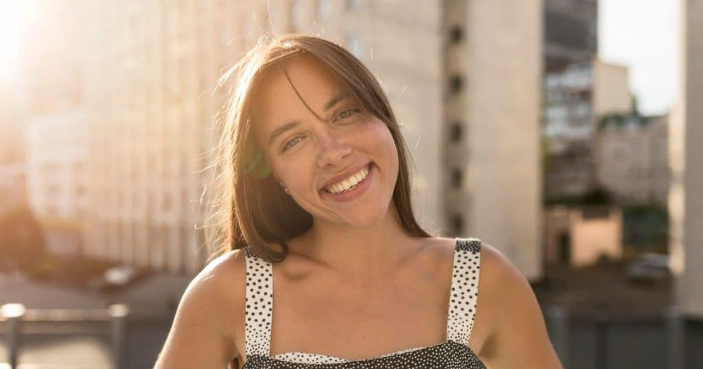 a very happy woman standing tall and proud as she finally understands how to turn rable on narcissists in her life and took her life back.