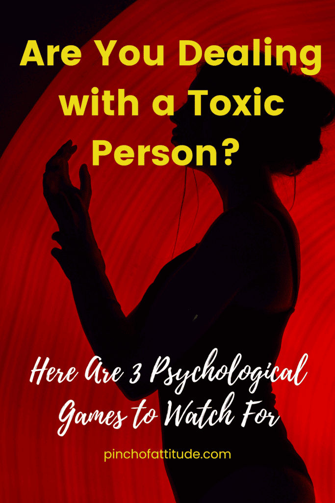 Pinterest - Pin with title "Are You Dealing with a Toxic Person? Here Are 3 Psychological Games to Watch For" showing a silhouetted woman with hands raised, set against a red circular background.