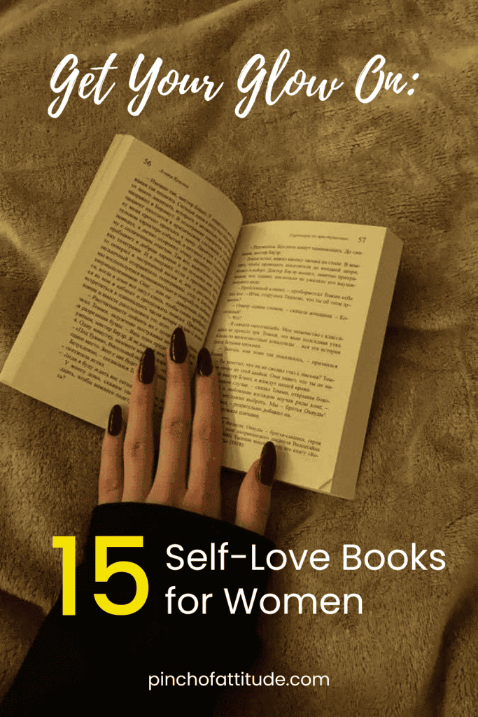 Pinterest - Pin with title "Get Your Glow On: 15 Self-Love Books for Women" showing a woman's hand with dark red nails holding the pages of a book placed on top of a comforter.