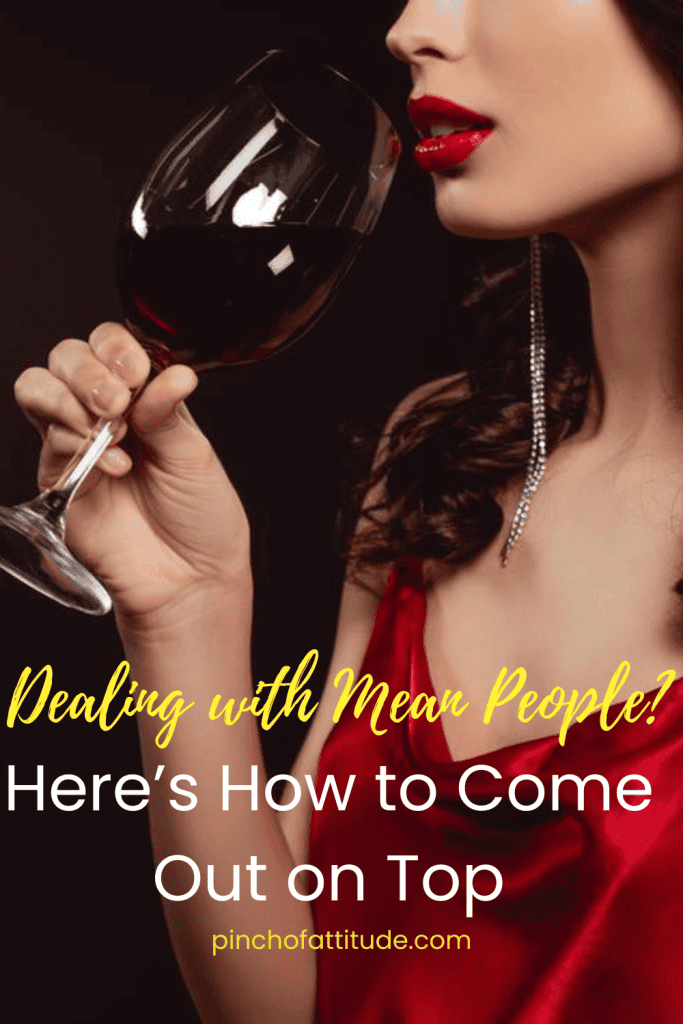 Pinterest - Pin with title "Dealing with Mean People? Here’s How to Come Out on Top" showing a woman in a red dress holding a glass of red wine with bold red lipstick and long earrings.