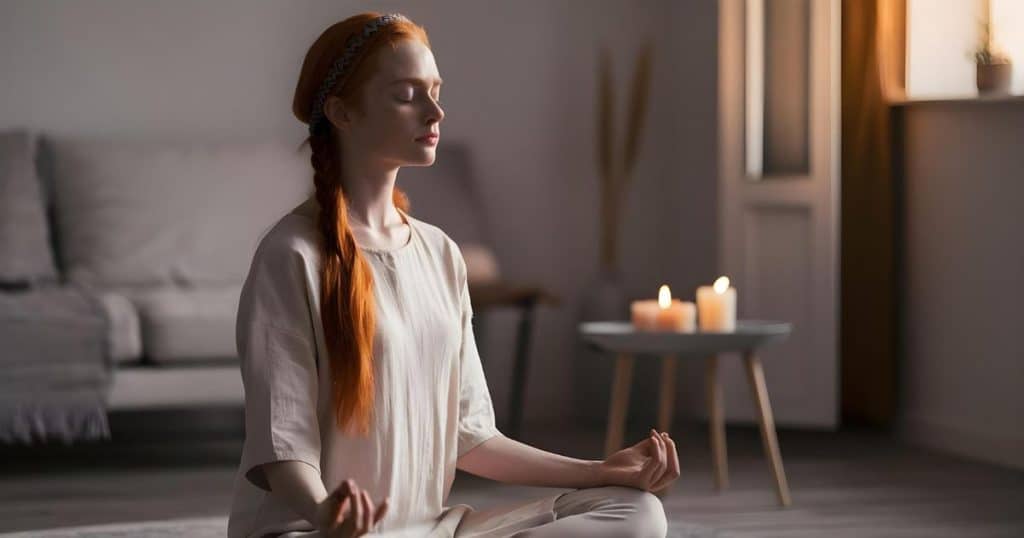 a woman meditating feeling very relax in her living room as she focuses on her future without her narcissistic partner.