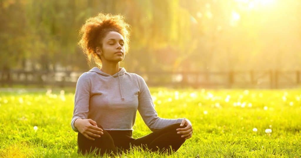 African american woman meditating in nature.