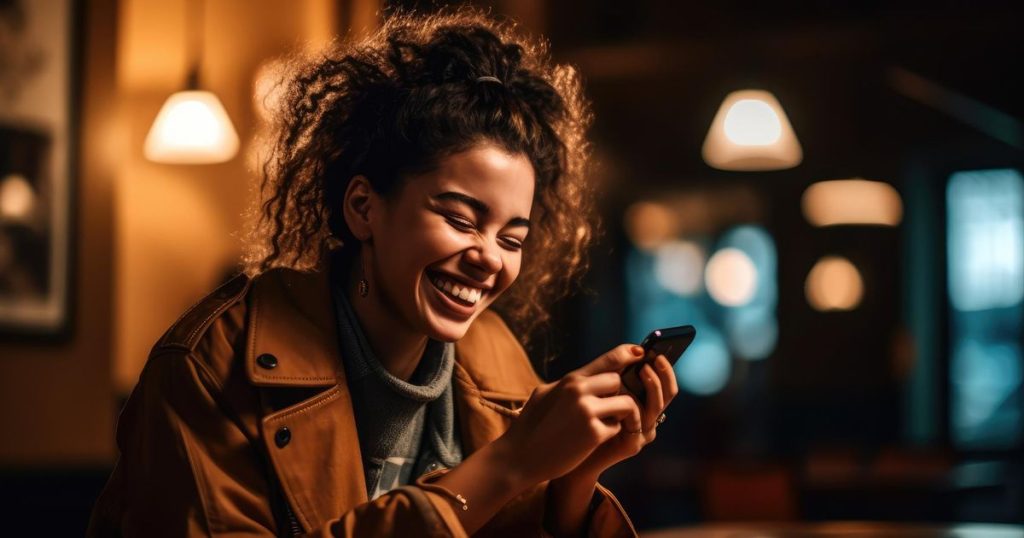 a coloured woman wearing a brown jacket sitting on her front porche of her house laughing while sending text messages to her family's flying monkeys.