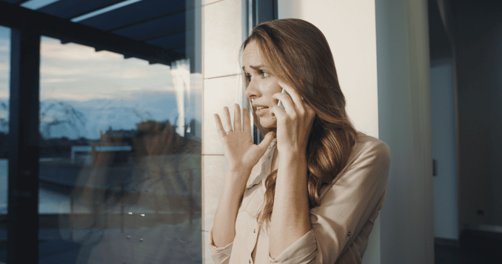 A woman on the phone looks overwhelmed as she tries to calm down during a call filled with guilt-tripping from her narcissistic mother.