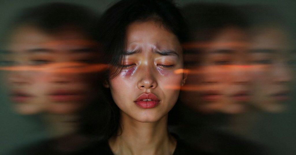 a close up picture of a beautiful asian woman with short black hair closing her yes in tears and her blurry images in the background.