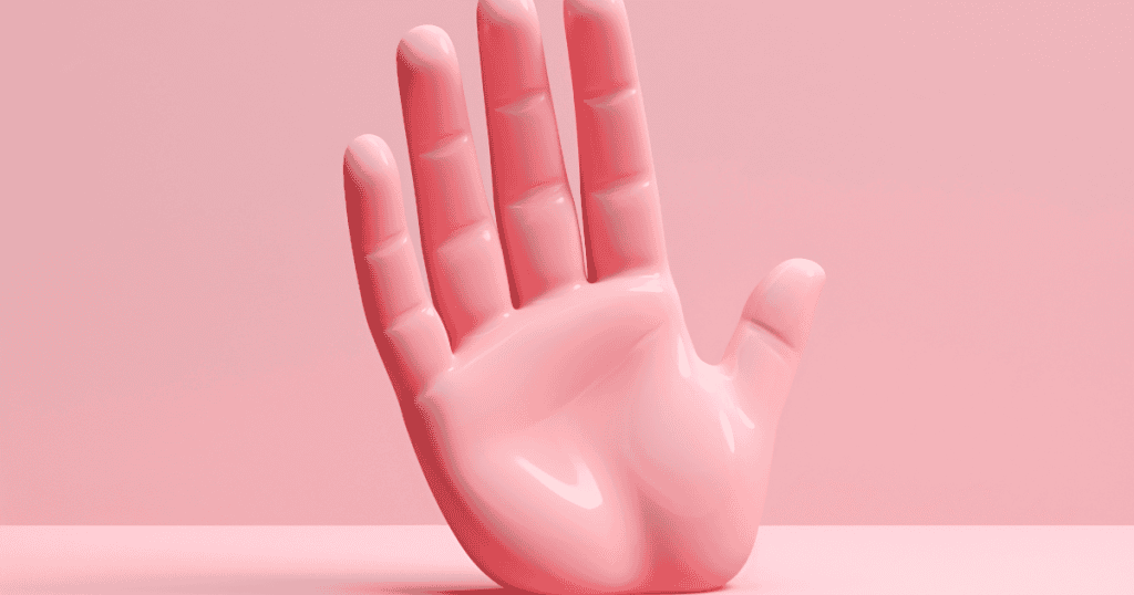 A glossy pink hand sculpture stands upright against a pastel background, symbolizing how clear boundaries reveal who respects your limits and who doesn't.