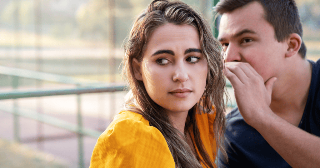 Two narcissists whispering together, representing how they launch smear campaigns to damage someone elseโs reputation.