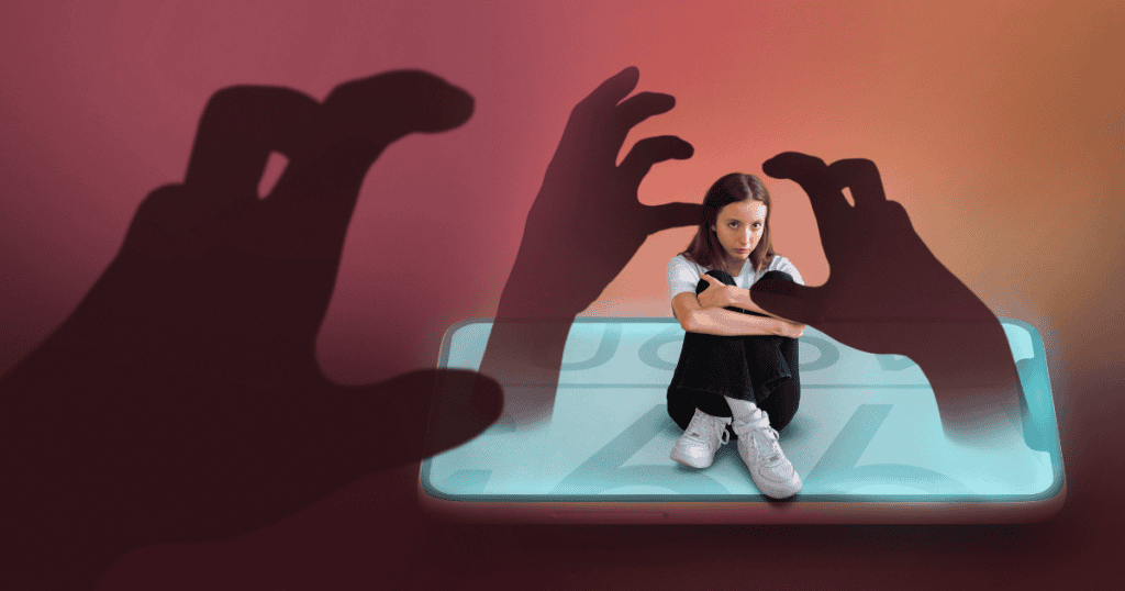 A young woman sits with arms wrapped around her knees on a smartphone screen as large shadowy hands reach for her, symbolizing how manipulation consumes and controls like an addiction.