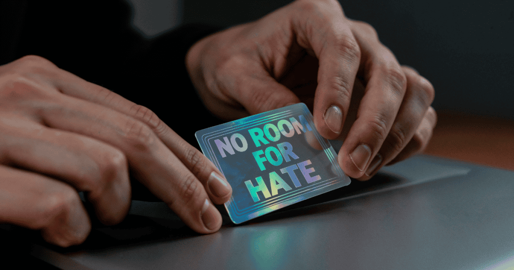 A person holds a holographic card reading โNo Room for Hate,โ underscoring the truth that love without respect is not genuine love.