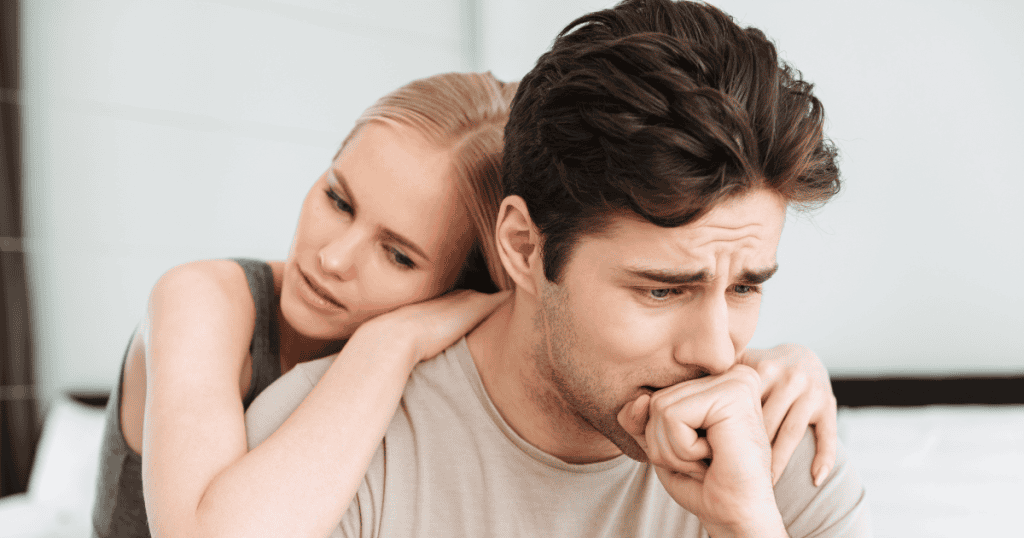 A woman leans on a distressed man’s shoulder, reflecting the heavy emotional toll and hidden price of trying to fix a narcissistic partner.
