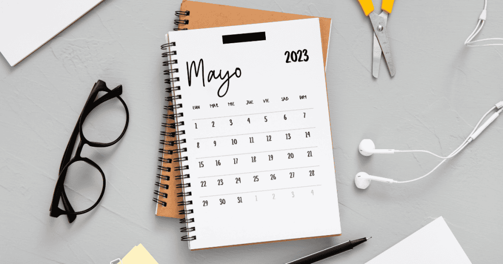 A spiral notebook calendar open to May 2023 on a desk with glasses, scissors, and earphones, which symbolizes using a calendar to build a timeline a narcissist can’t rewrite.