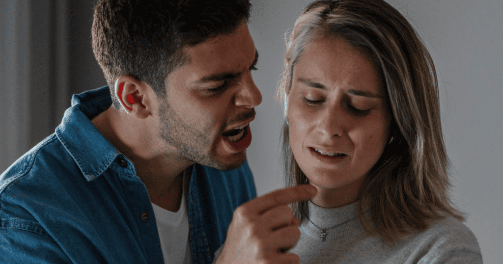 A man angrily yells while pointing at a woman who looks distressed, illustrating the painful reality of why narcissists won’t ever change.