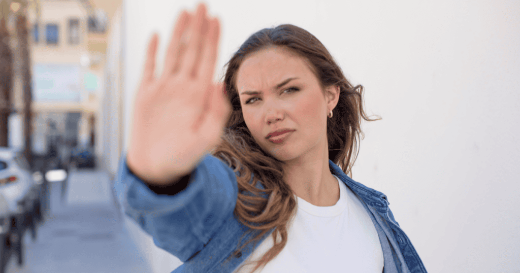 A woman holding her hand up in a firm stop gesture, symbolizing the refusal to give blind loyalty to a narcissist.