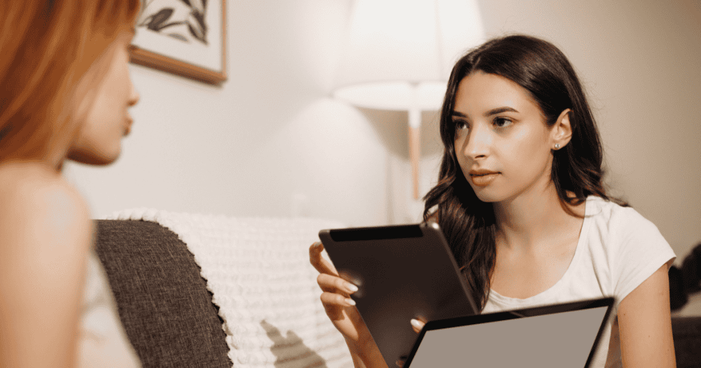 A woman holding a tablet while testing someone for narcissistic behavior.