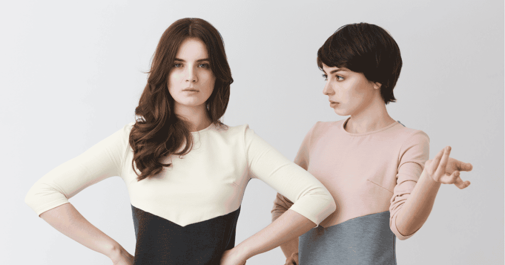 Two women stand close together, one looking serious while the other gestures toward her, illustrating how narcissists scan subtle signals before a word is spoken.