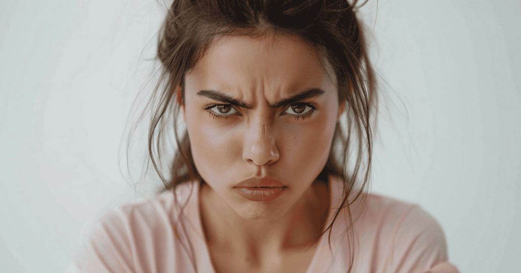 A young woman stares forward with a tense, angry expression, showing how narcissistic abuse can exist in quiet, subtle moments rather than explosive ones.