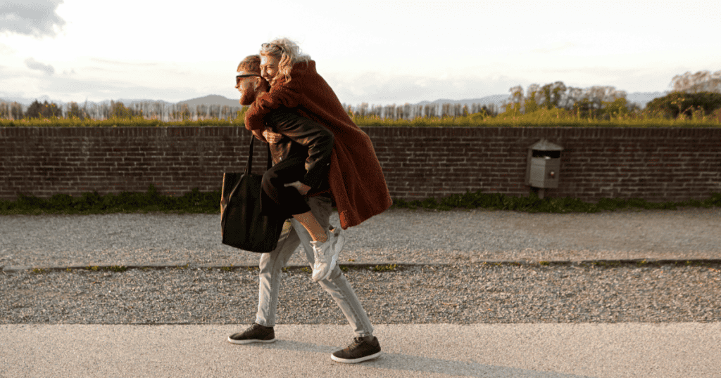 A man carries a woman on his back while walking away, showing that leaving a toxic family can be an act of love.