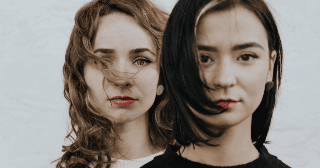 Two women with intense expressions stand side by side, symbolizing how narcissists quickly switch faces to keep others off balance.