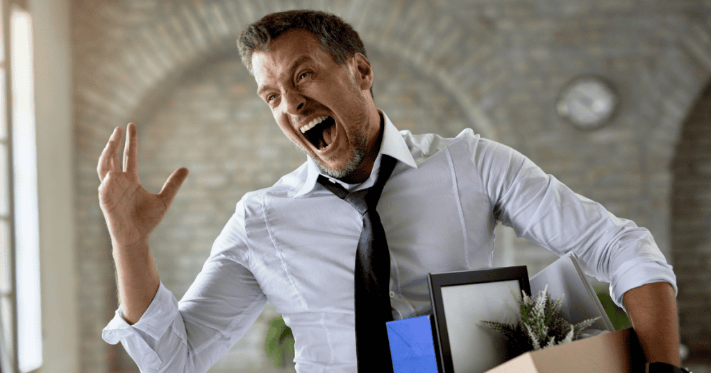 A man in office attire shouts with exaggerated enthusiasm while holding a box of belongings, symbolizing how narcissists often keep getting promoted despite toxic behavior.