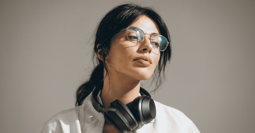 A woman wearing glasses and headphones looks confidently into the distance, reflecting the unapologetic strength needed to say no to a narcissist.