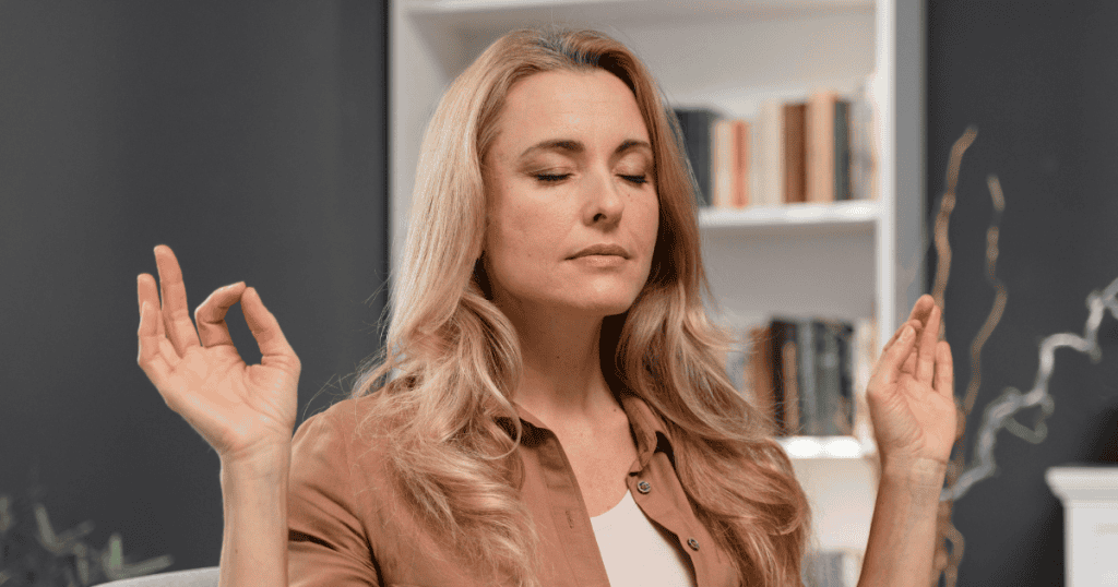 A woman with her eyes closed and hands in a meditation mudra appears centered and calm, demonstrating the practice of establishing inner boundaries to shield one's peace.