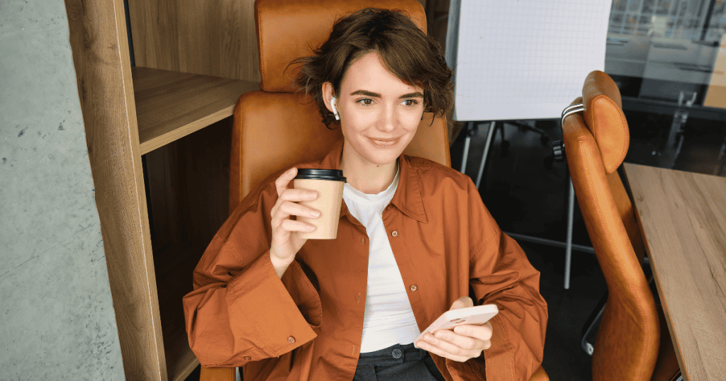A person sits relaxed with a coffee cup and phone in hand, representing the calm clarity that comes from telling a narcissist that no is a complete sentence.