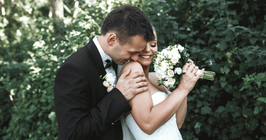 A bride and groom embrace joyfully outdoors, symbolizing the freedom in truth.