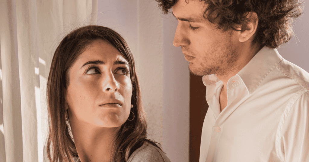 A woman looks up with doubt as a man stares down at her, representing the lie of “not enough.”