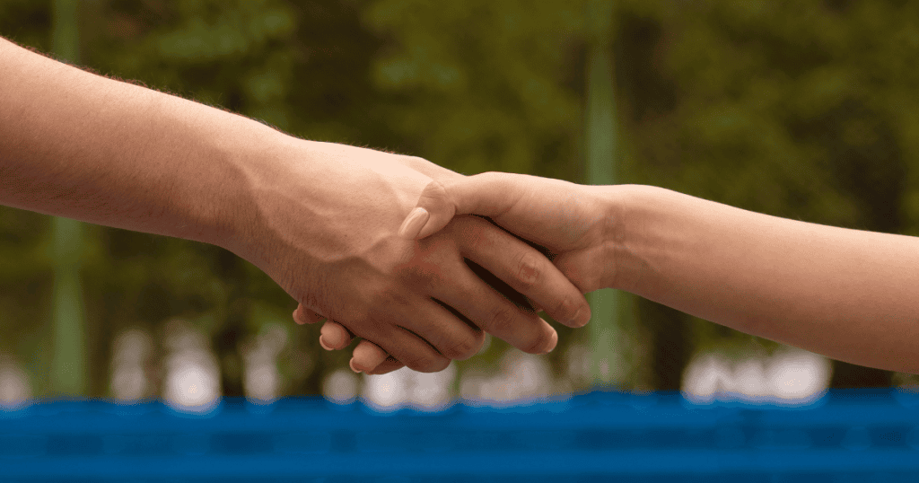 Two people shake hands outdoors, symbolizing the respected boundary.