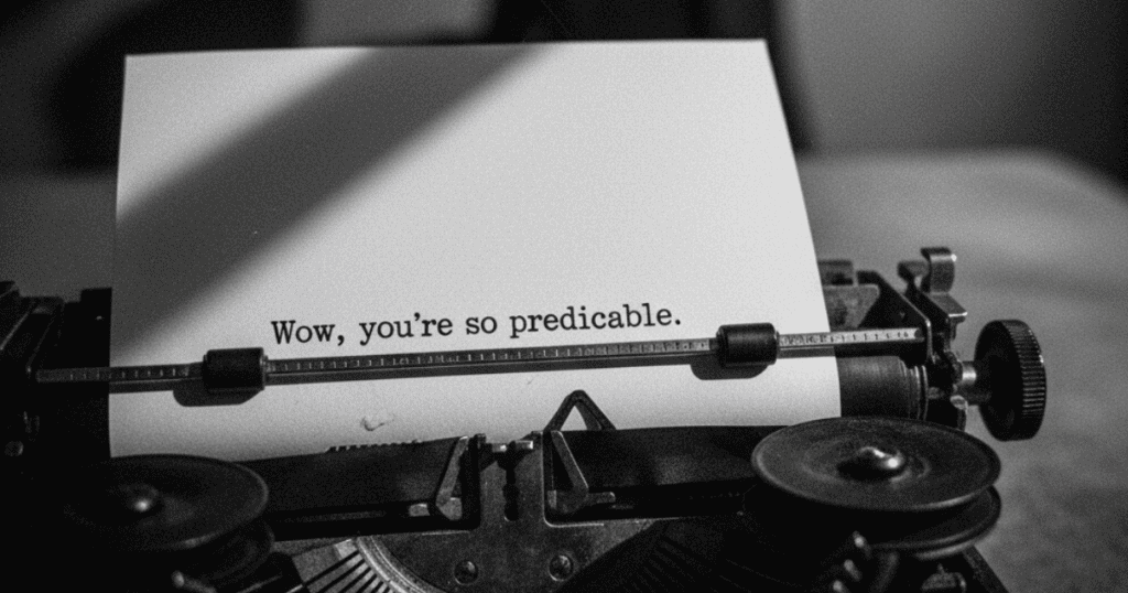 A vintage typewriter presses the line 'Wow, you’re so predictable,' while a shadowy silhouette recoils as if the script is interrupted.