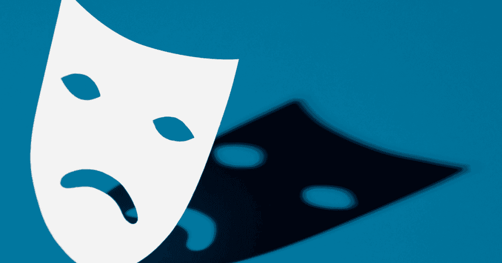 A white theatrical mask with a sad expression casting a dark shadow on a blue background, symbolizing the victim mask.