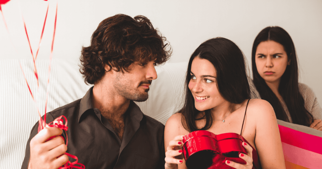 A couple celebrates their anniversary while someone in the background glares with resentment, hinting at the tension and jealousy narcissists stir up during special occasions.