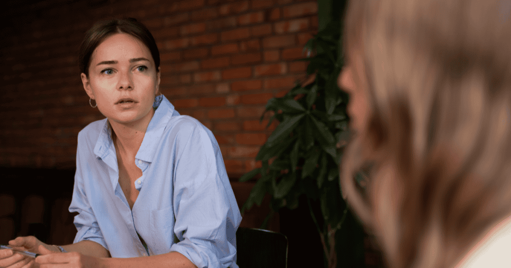 Woman listening intently with a serious, reflective expression, symbolizing the process of learning to observe behavior over words after experiencing narcissistic abuse.