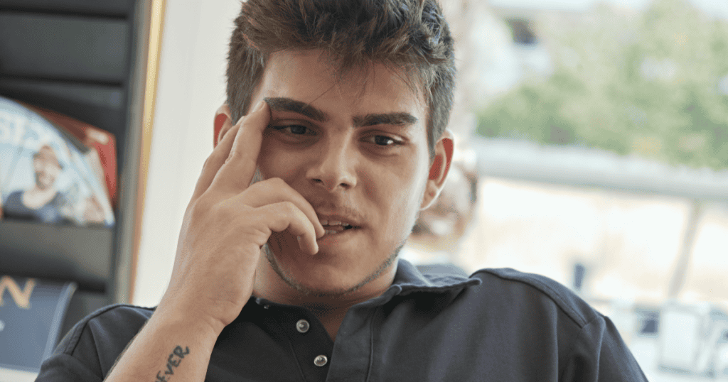 Young man with a smug, calculating expression, symbolizing the cruelty and manipulative phase of narcissism that emerges during early adulthood.