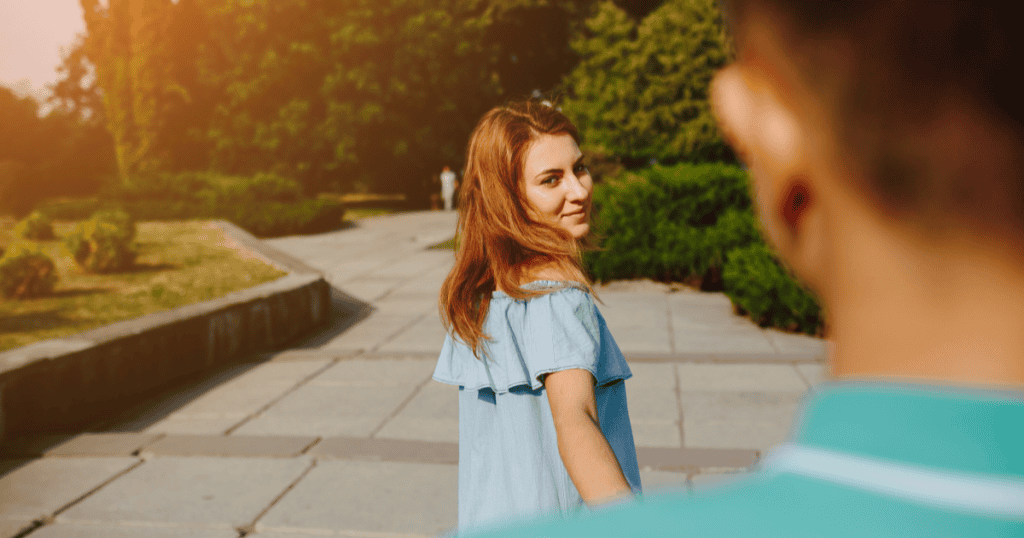 A woman looks back calmly while walking away from someone behind her, symbolizing the shift that happens when you stop chasing a narcissist after a breakup.