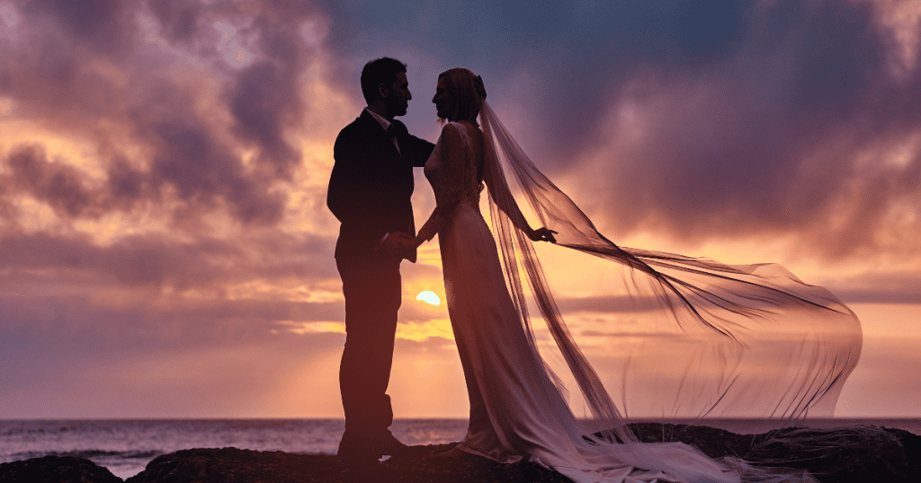 A bride and groom stand silhouetted against a sunset, depicting the grand romantic fantasy that serves as a loaded topic when introduced too early.