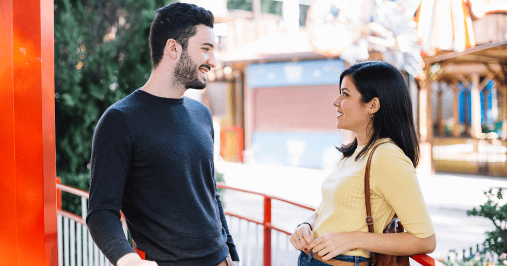 A man and woman smile at each other in a bright outdoor setting, where warmth serves as a fuel for someone else’s needs.