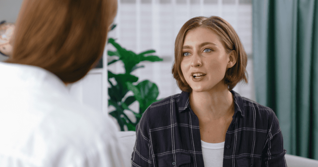 A woman speaks openly to another person in a calm, direct conversation, symbolizing a survivor exposing the narcissist to others after narcissistic abuse.