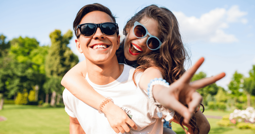 A young man giving a woman a piggyback ride while they both smile, illustrating a dynamic that should ideally feel effortless and supportive.
