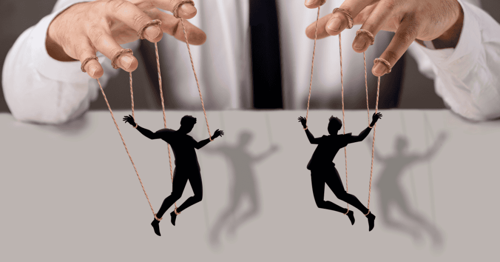 A person’s hands control small figures with strings like a puppeteer, demonstrating how external influence can dictate every movement.