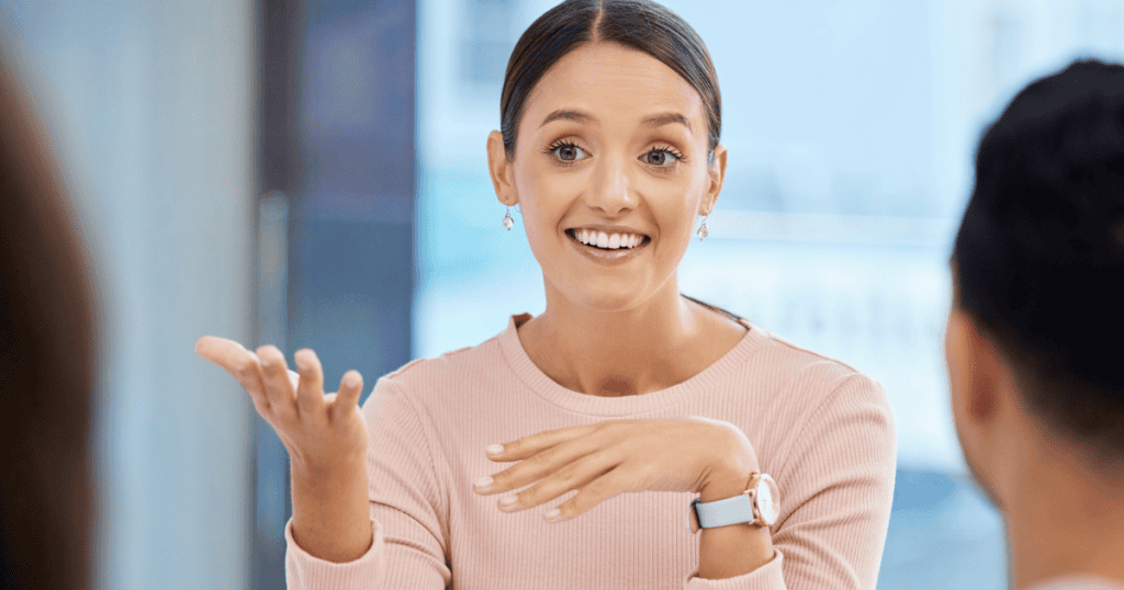 A smiling woman gestures actively during a conversation, projecting the energy of someone establishing a definitive personal standard.
