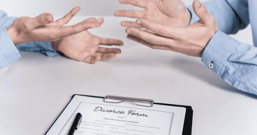 Two people gesturing with open palms over a divorce form on a desk, capturing a moment of calculated obstruction.