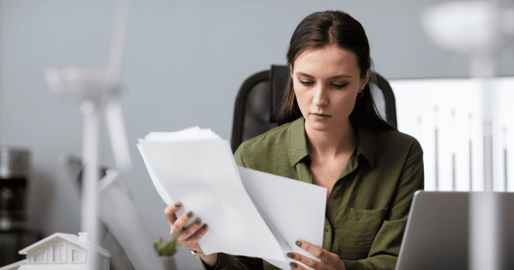 A woman in an office carefully sifting through various documents, maintaining control over the final version of her narrative.