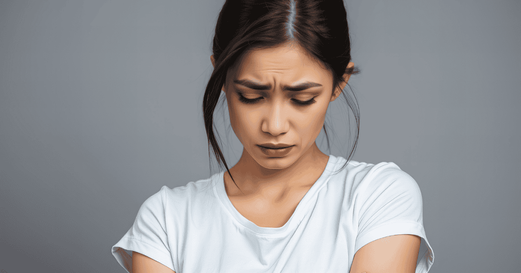 A woman with a pained expression looks downward with furrowed brows, capturing the internal sting of a betrayed reality that goes deeper than a single act.