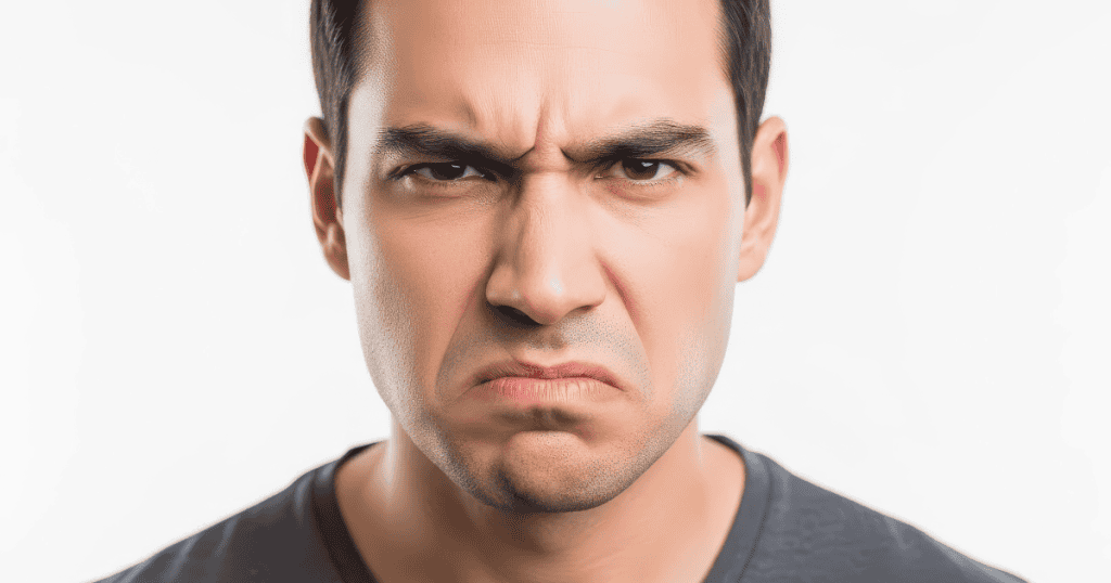 A man's face is pulled into a tight, exaggerated frown, capturing the intense peak of a bad mood.