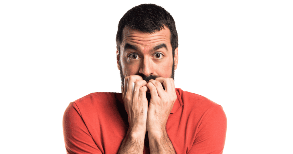 A man in a red polo shirt stares wide-eyed into the camera while biting his fingernails, embodying a deep-seated vulnerability that is rarely shown to the world.