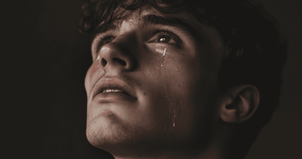A young man gazes upward with tears streaming down his face, portraying an emotional display that may serve an ulterior motive.